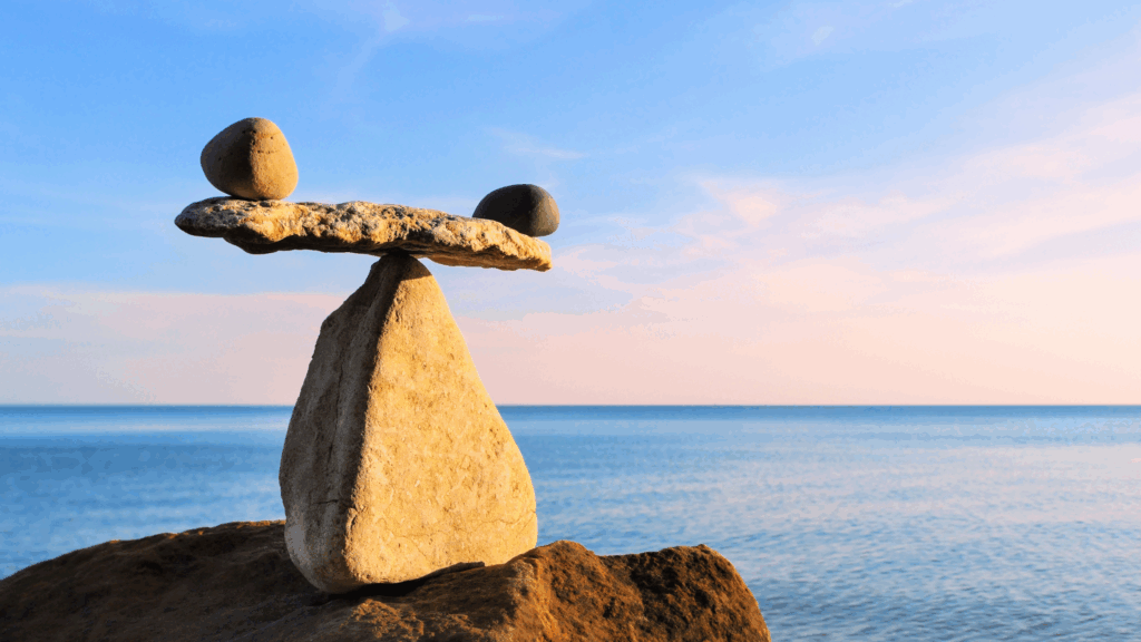 Stacked stones balanced on a beach representing harmony, balance, and wellness